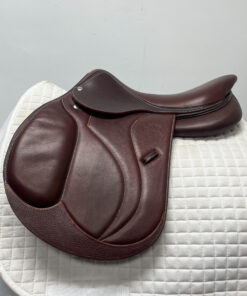 A high quality Devoucoux Biarritz S Jump Saddle on top of a white blanket.