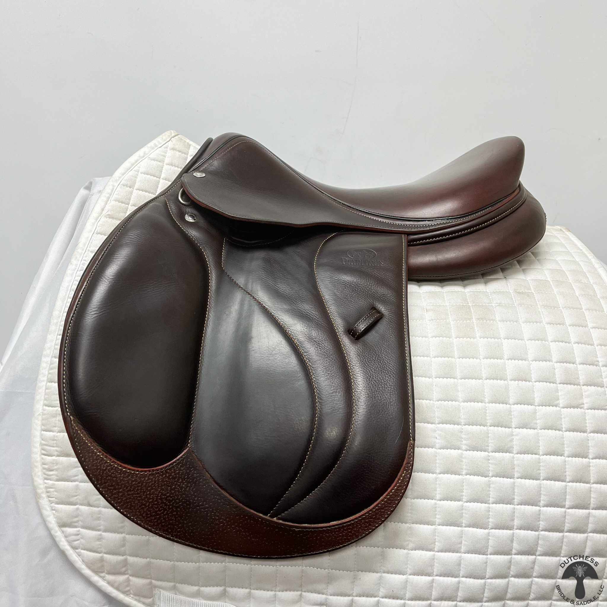 A Devoucoux Biarritz O Jump Saddle 2176 on top of a white blanket.