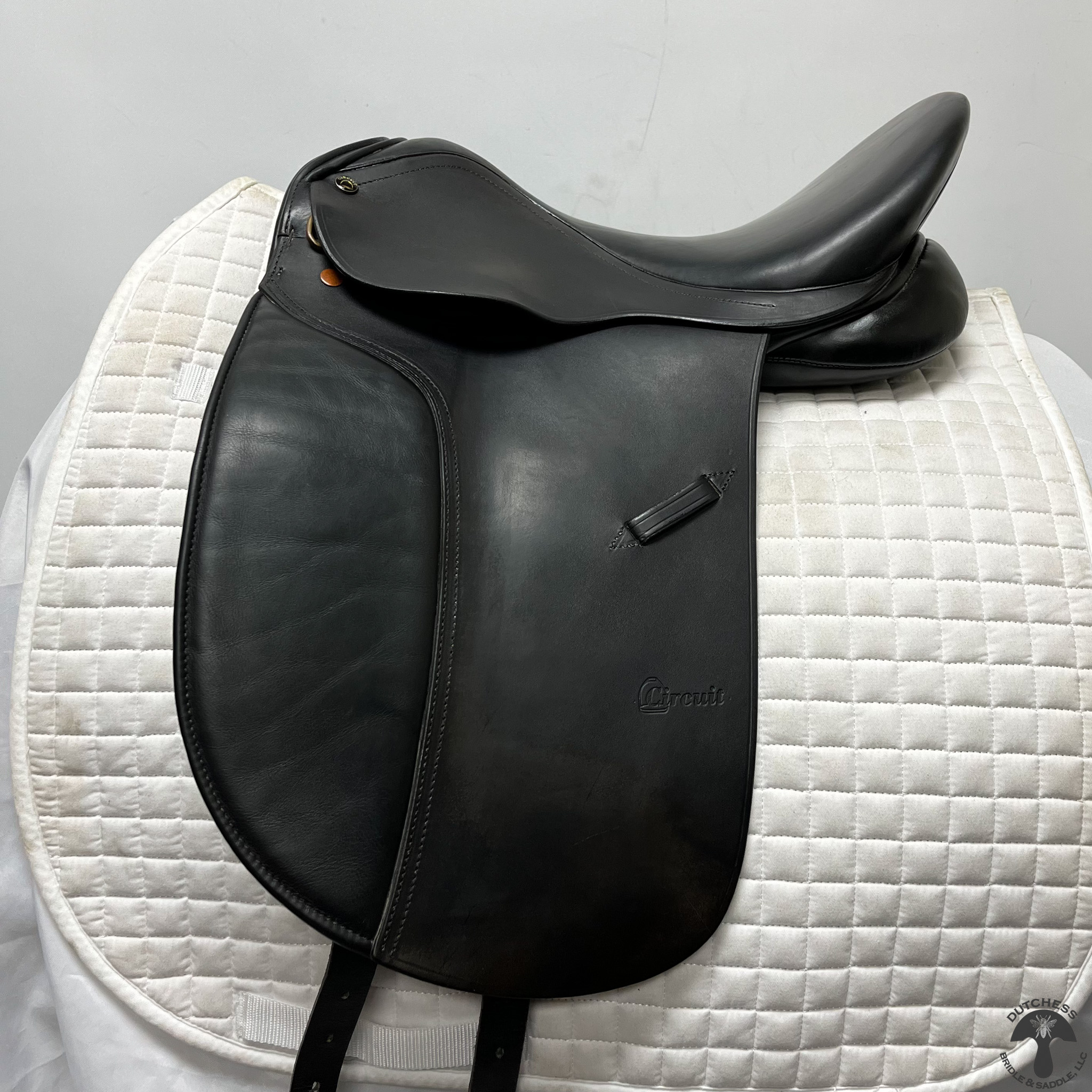 A used Circuit Premiere Dressage Saddle 2178 sitting on top of a white mat.