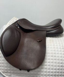 A used Arena All Purpose Saddle sitting on top of a white blanket.