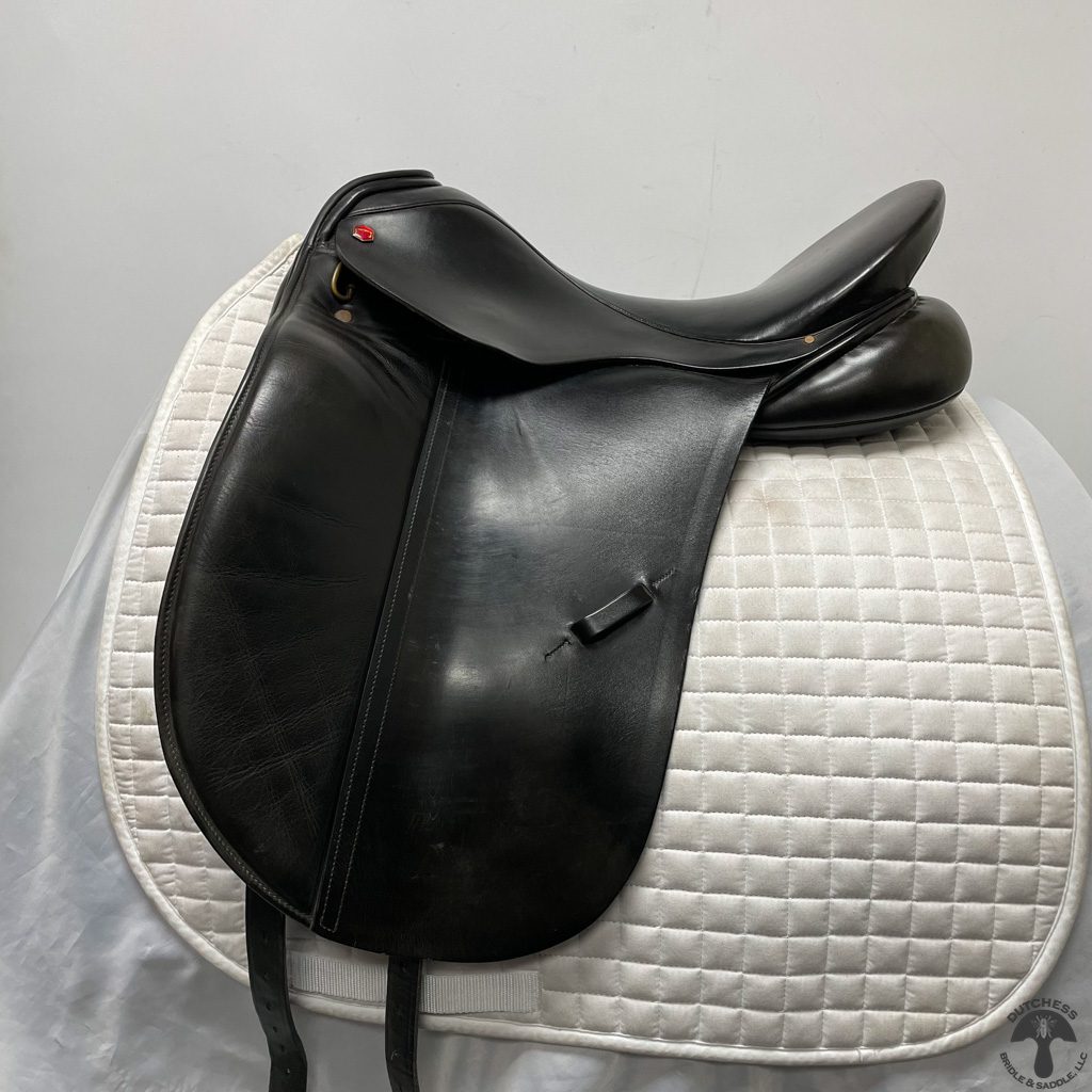 Black leather dressage saddle on a white pad.