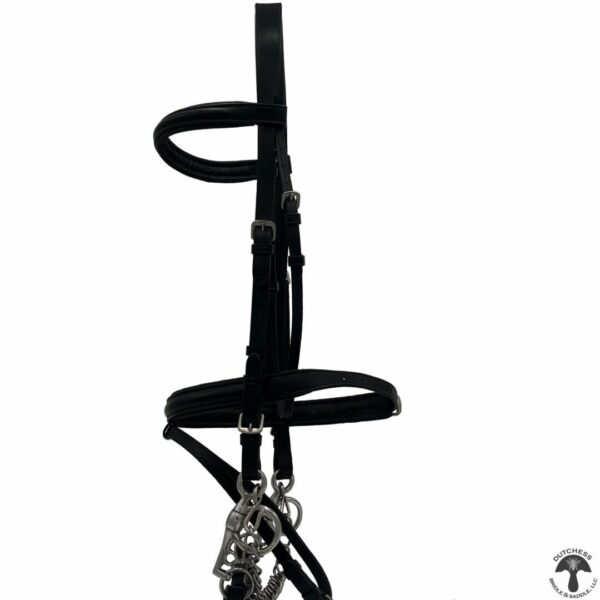 A black bridle and reins hanging on the wall.