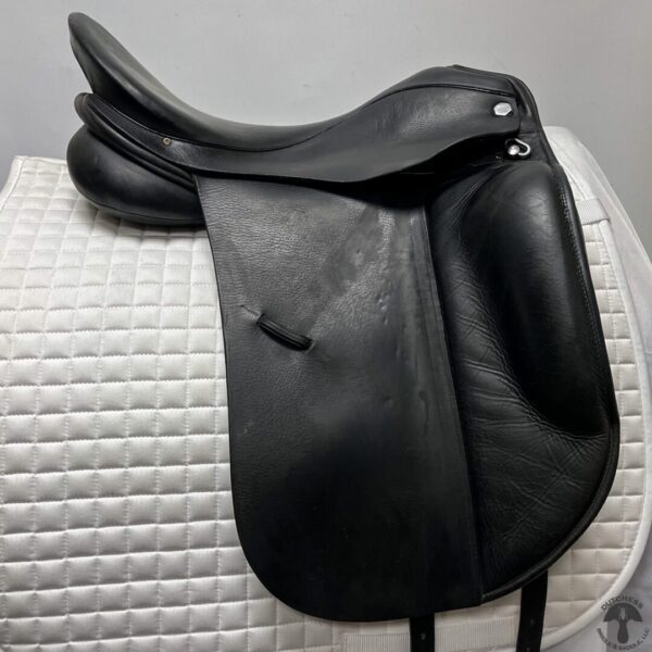 A black saddle sitting on top of a white pad.