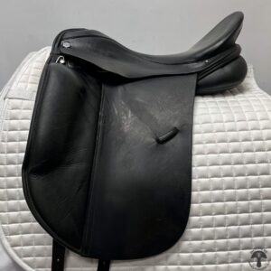 A black saddle sitting on top of a white pad.