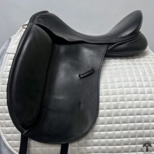 A black saddle sitting on top of a white pad.