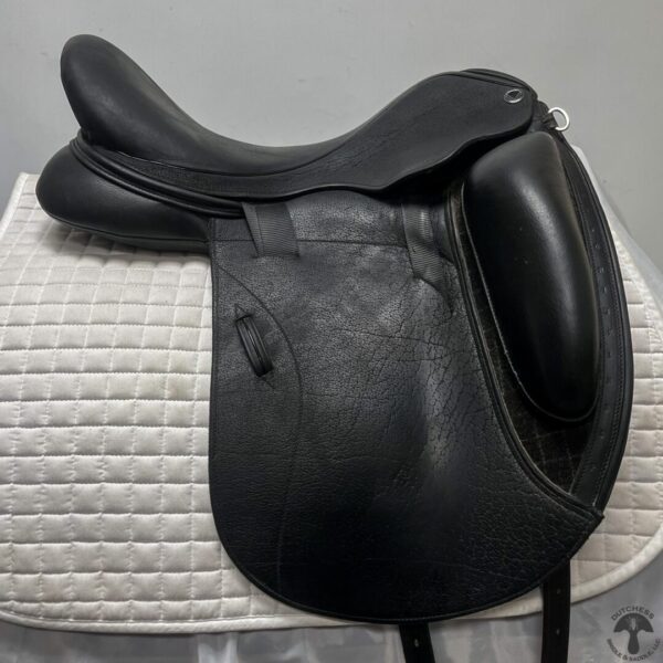 A black saddle sitting on top of a white pad.