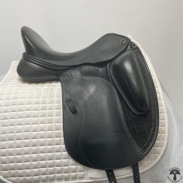 A black saddle sitting on top of a white pad.