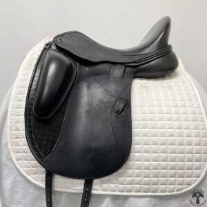 A black saddle sitting on top of a white pad.