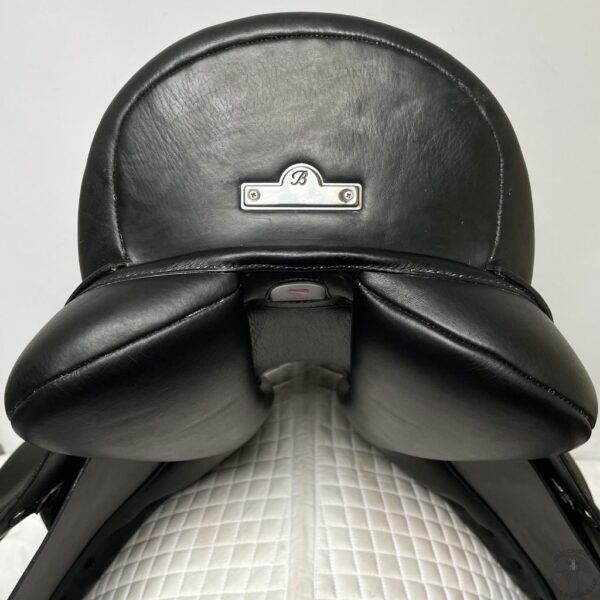 A close up of the back end of a black saddle.