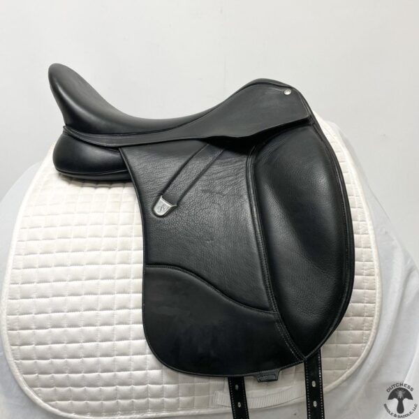 A black saddle sitting on top of a white pad.