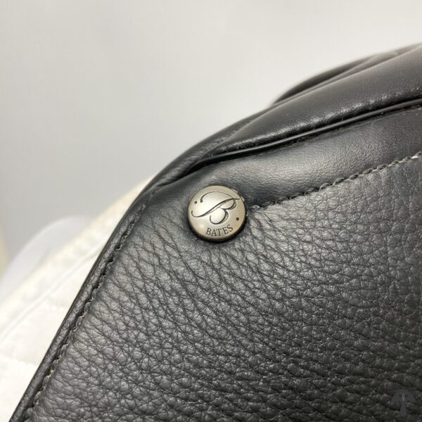 A close up of the button on a leather bag