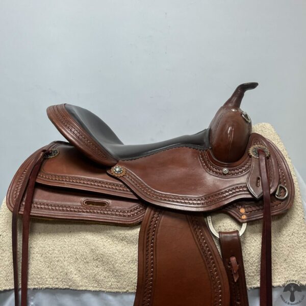 A saddle is sitting on top of the blanket.