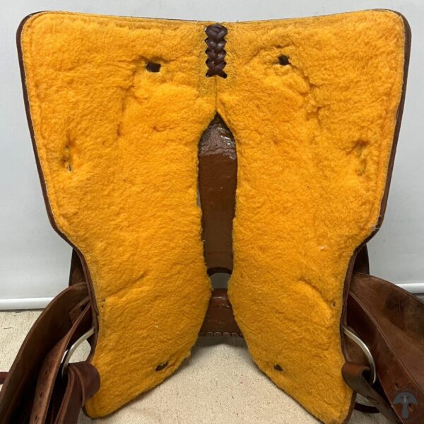 A yellow saddle bag with two straps on the back.