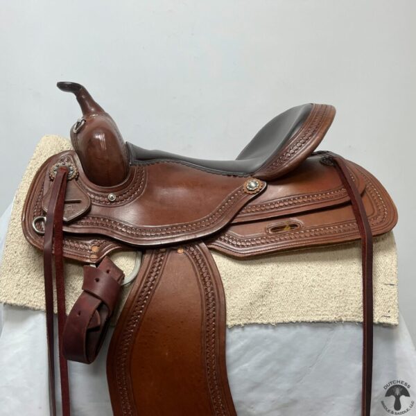 A saddle is sitting on top of the blanket.