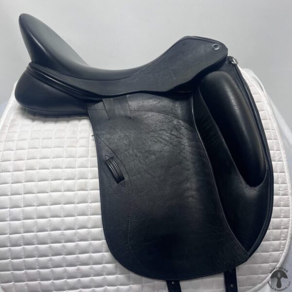 A black saddle sitting on top of a white mat.