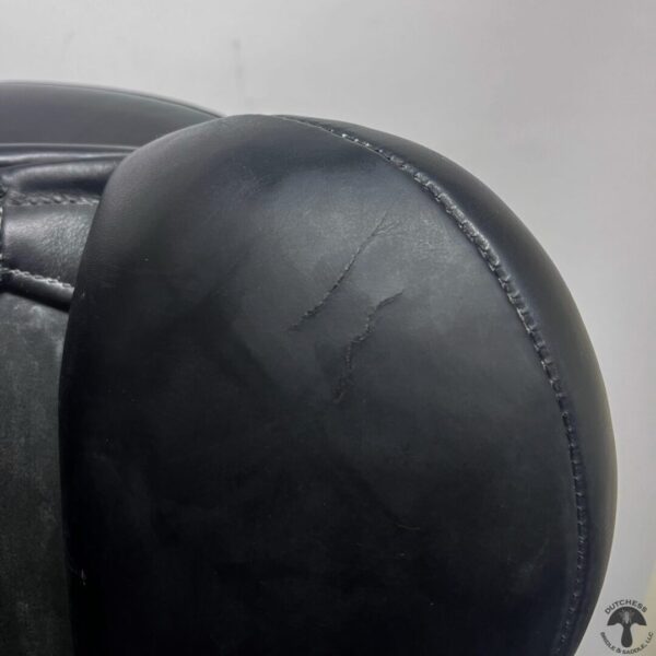 A close up of the back end of a black chair.