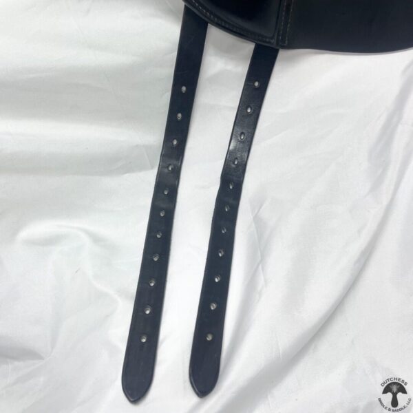 A pair of black leather straps on top of white sheets.