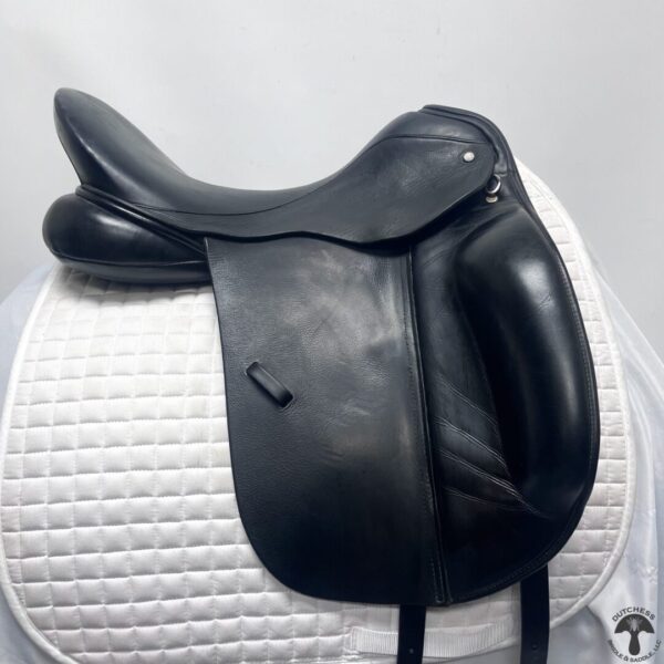 A black saddle sitting on top of a white pad.