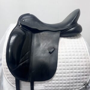 A black saddle sitting on top of a white horse.