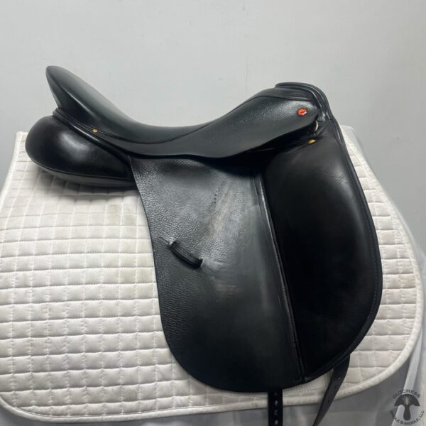 A black saddle sitting on top of a white pad.