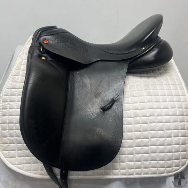 A black saddle sitting on top of a white mat.