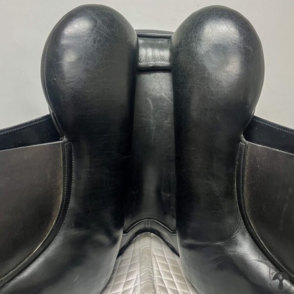 A close up of the back end of a black leather saddle.