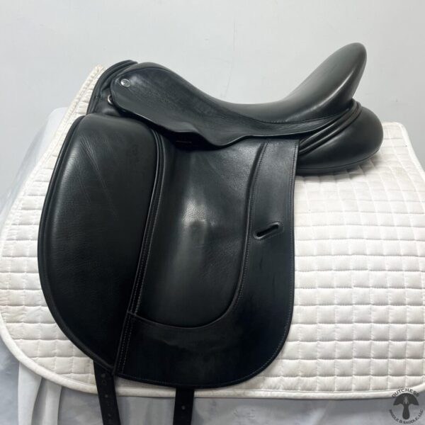 A black saddle sitting on top of a white mat.