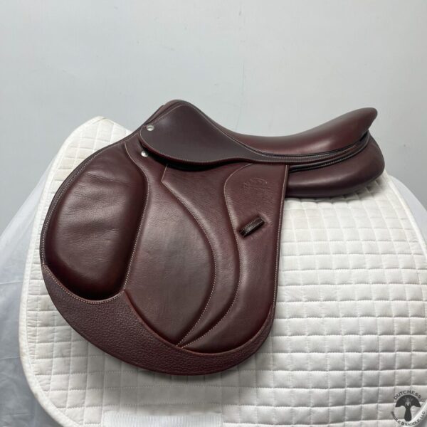 A saddle sitting on top of a white blanket.