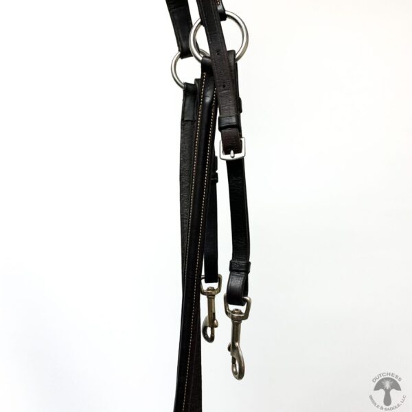 A pair of black leather dog leashes hanging on the wall.