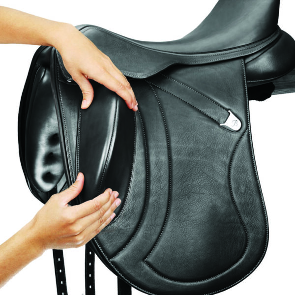 A person is holding the saddle on their horse.