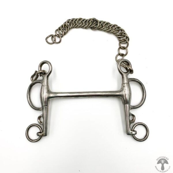 A metal horse bit with chain hanging off of it.