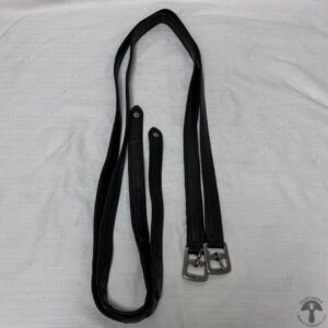 A pair of black leashes on top of a bed.