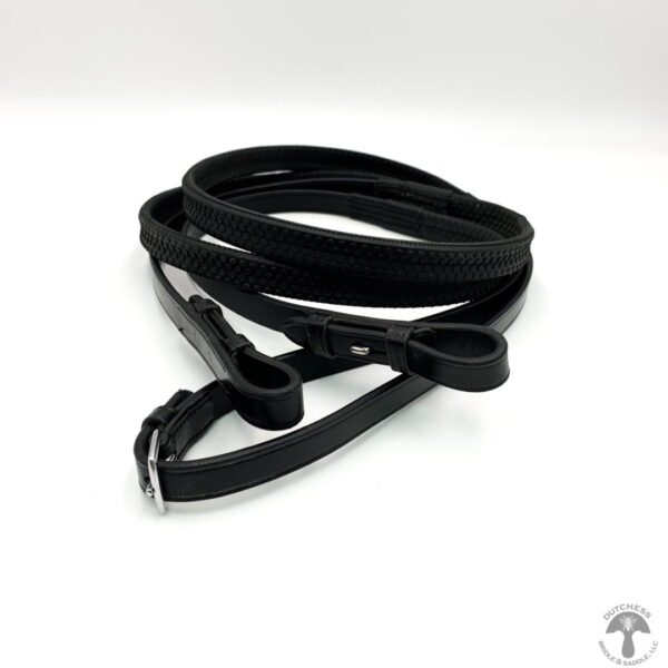 A black leather leash is laying on the ground.