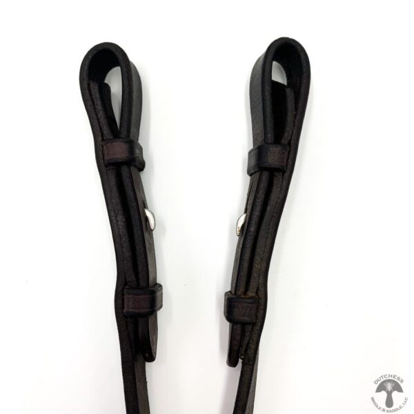 A pair of black leather riding reins on white background.