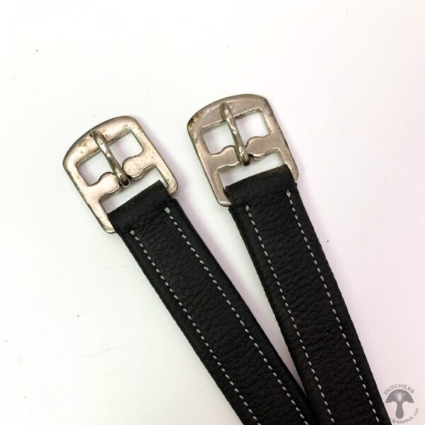 A pair of black leather straps with silver buckles.