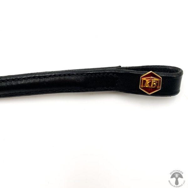 A close up of the handle on a black leather strap