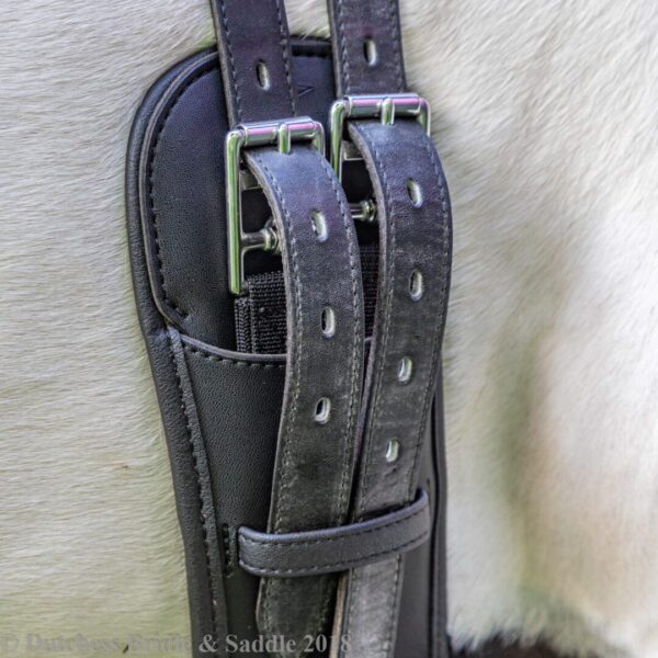 A close up of the straps on a leather holster