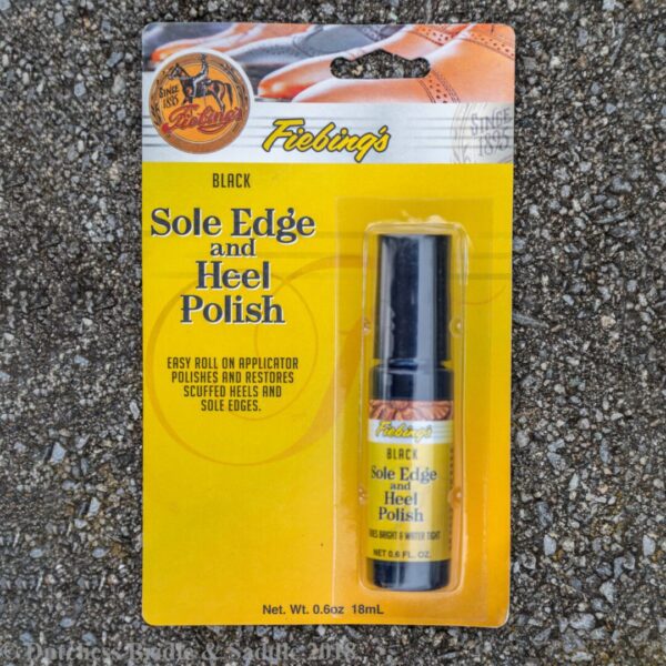 A package of shoe polish on the ground.