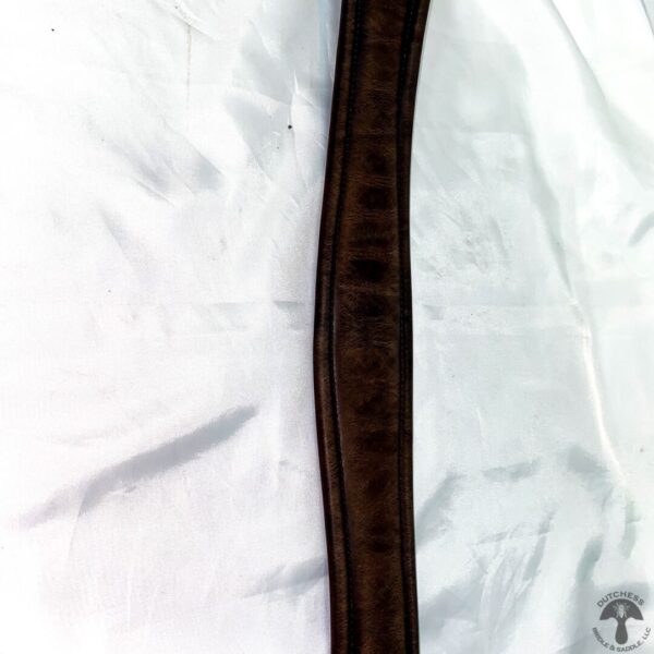 A brown leather strap on white fabric