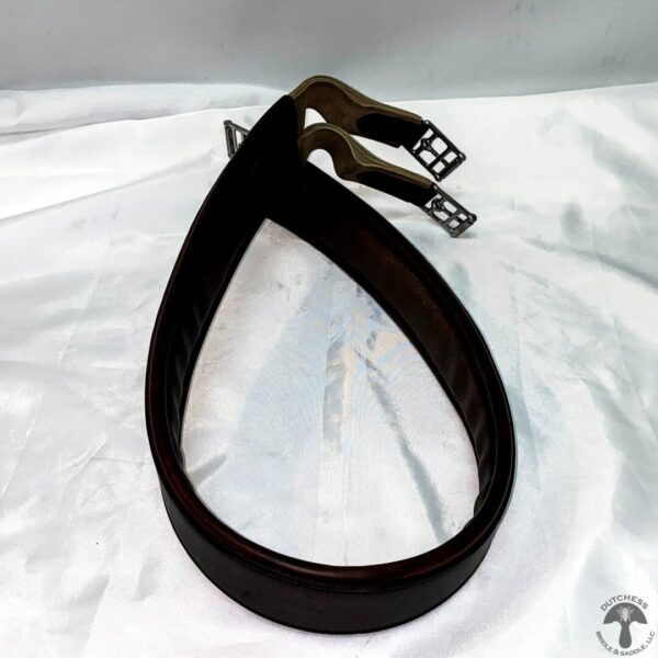 A pair of black leather straps on top of white fabric.