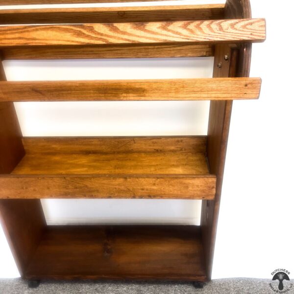 A wooden shelf with two shelves and wheels.