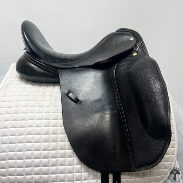 A black saddle sitting on top of a white surface.