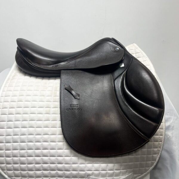 A close up of a black saddle on top of a white pad