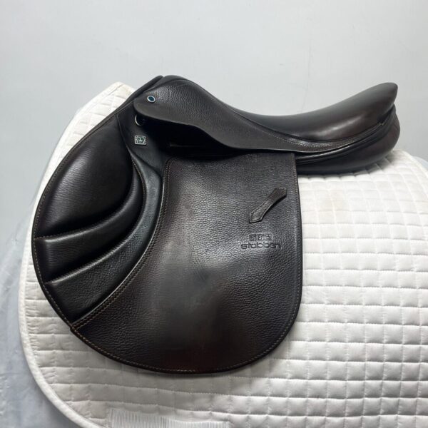 A close up of the saddle on a white pad