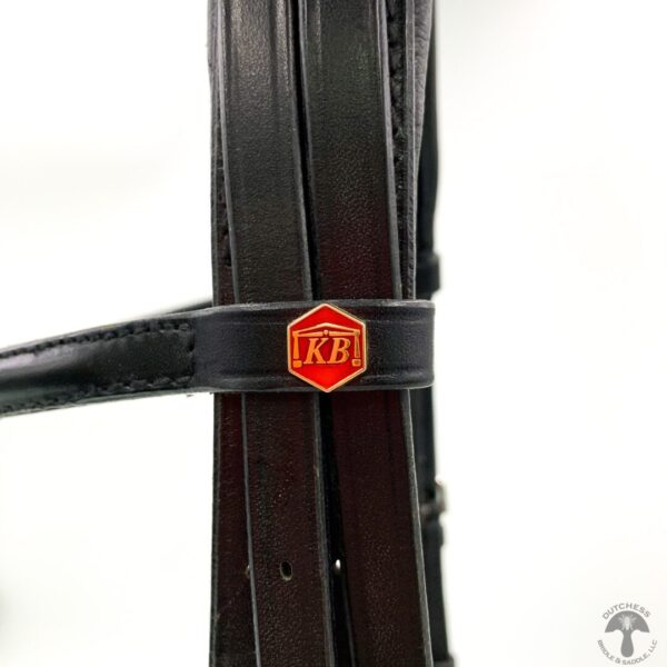 A close up of the red and black logo on a horse bridle.