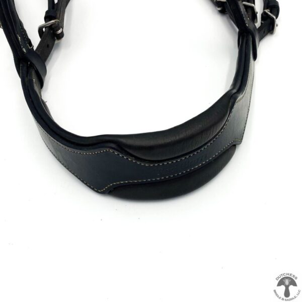 A close up of the strap on a black leather neck harness