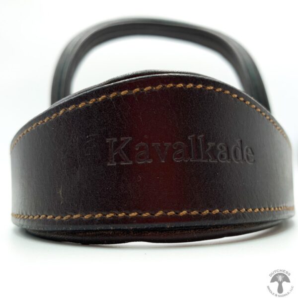 A close up of the handle on a brown leather bag