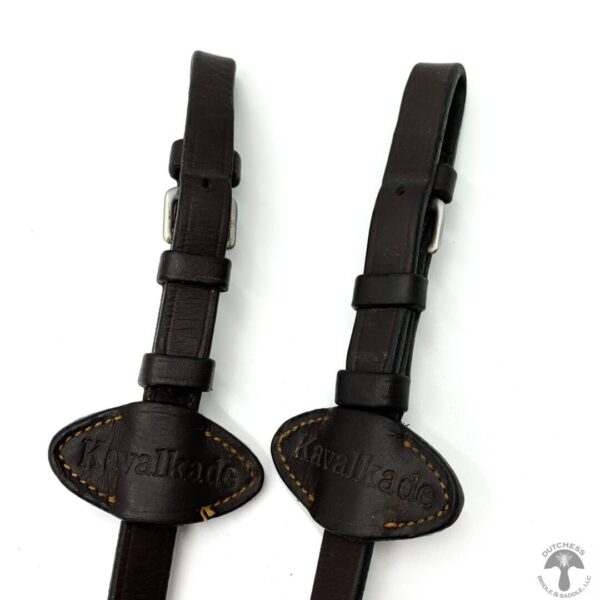 A pair of black leather straps with a brown handle.