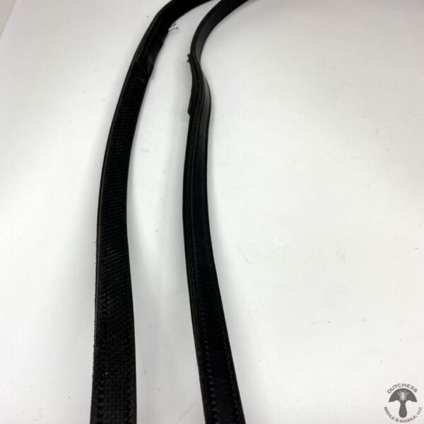 A pair of black straps on top of a white table.