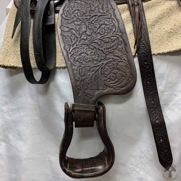 A brown leather purse with a horse shoe on the strap.